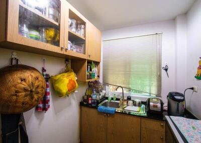 Compact kitchen space with wooden cabinets and countertop appliances