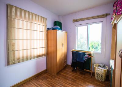 Small bedroom with a window and wooden furniture