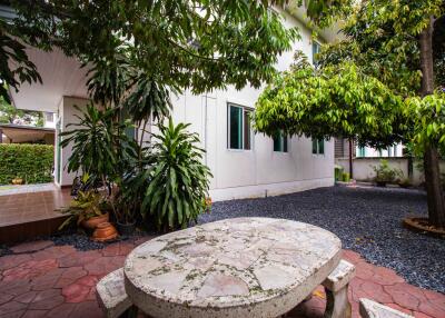 Outdoor patio with table and lush greenery