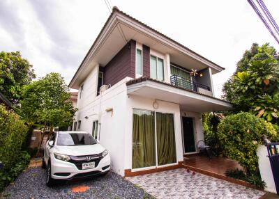 Two-story residential building with driveway and garden