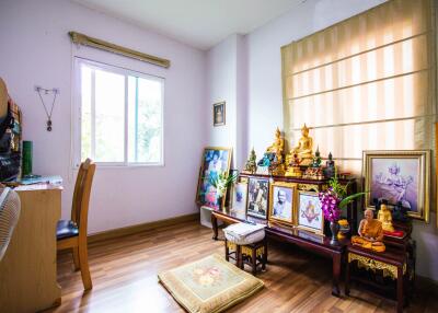 Bedroom with wooden floors and religious decorations