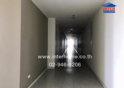 Long corridor in a residential building with tiled flooring