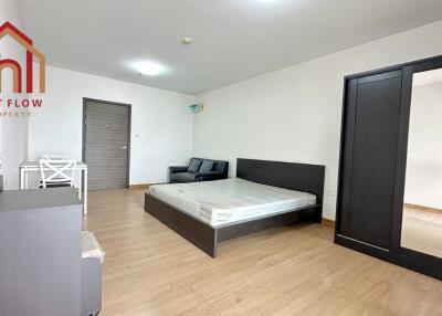 Spacious bedroom with bed, wardrobes, and seating area