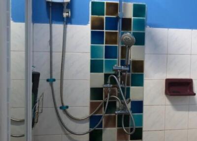 Bathroom shower area with water heater and colorful tiles