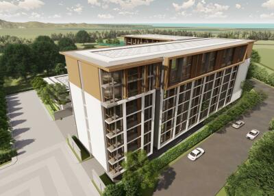 Aerial view of modern apartment building with greenery and parking