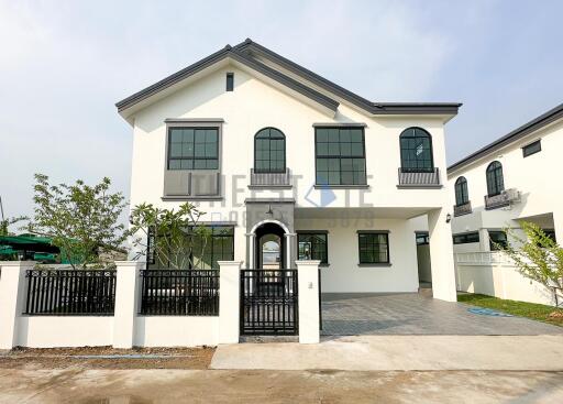 Front view of a modern two-story house with large windows and gated entry