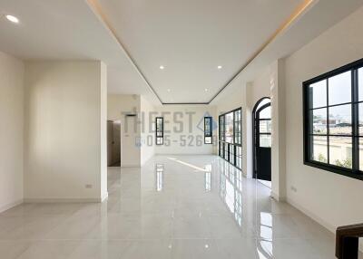 Spacious and bright living area with large windows and tiled flooring