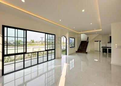 Spacious modern living area with large windows and staircase