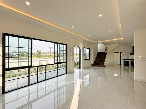 Spacious modern living area with large windows and staircase