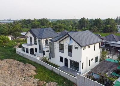 Aerial view of a modern multi-story residential building with landscaped surroundings