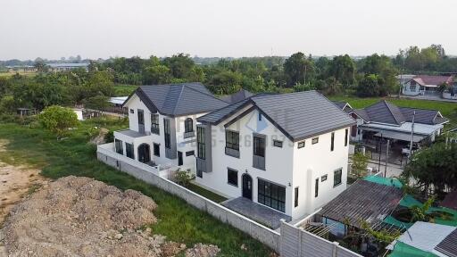 Aerial view of a modern multi-story residential building with landscaped surroundings