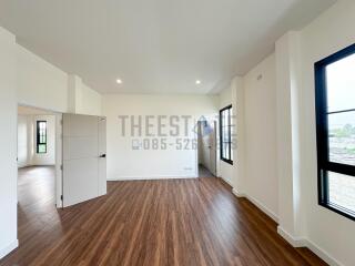 Empty living room with wooden floors and large windows