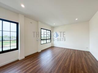 Spacious living room with large windows and wooden flooring