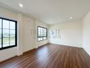 Spacious living room with large windows and wooden flooring