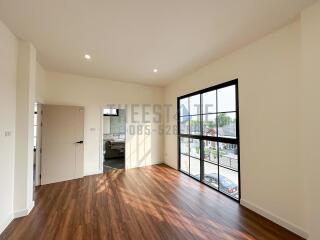 Spacious and well-lit living room with hardwood flooring and large windows