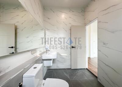 Modern bathroom with white fixtures and marble tiles