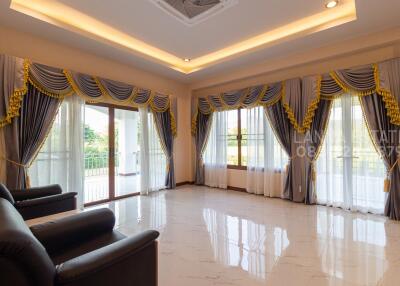 Spacious and well-lit living room with luxurious curtains and marble flooring