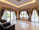 Spacious and well-lit living room with luxurious curtains and marble flooring