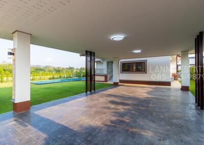 Covered outdoor area with adjacent lawn and small pool