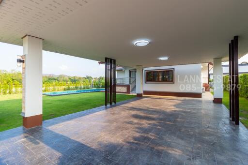 Covered outdoor area with adjacent lawn and small pool