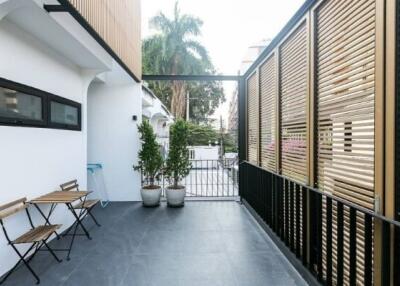 Outdoor balcony with seating area and potted plants