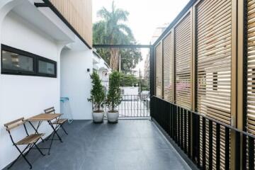 Outdoor balcony with seating area and potted plants