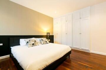 Spacious modern bedroom with comfortable bed and ample closet space