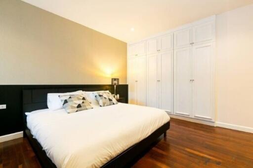 Spacious modern bedroom with comfortable bed and ample closet space