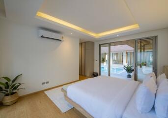 Spacious bedroom with a view of the pool and built-in air conditioning