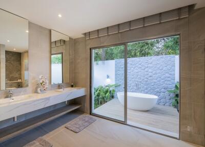 Modern bathroom with double sinks, large mirror, and view of outdoor bath