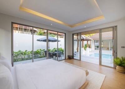 Spacious bedroom with large windows and pool view