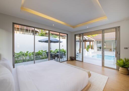 Spacious bedroom with large windows and pool view