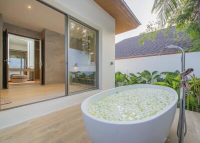 Luxurious outdoor bath with floral decoration and garden view