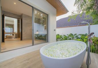 Luxurious outdoor bath with floral decoration and garden view