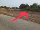 Vacant land with arrow pointing to the property