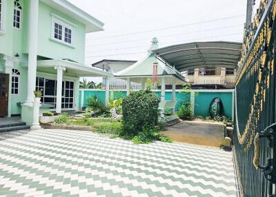 Two-story house with a spacious courtyard, garden, and carport