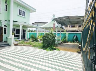 Two-story house with a spacious courtyard, garden, and carport