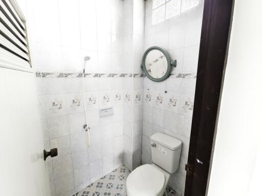 Small bathroom with toilet and wall-mounted shower