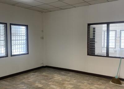 Empty room with tiled floor, grilled windows, and ceiling lights