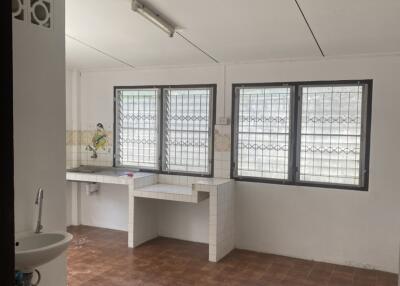 Simple kitchen with tiled flooring and several windows