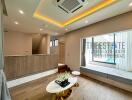 Modern living room with wooden flooring, recessed lighting, and a view of the pool