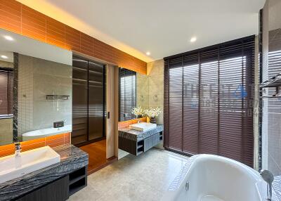 Modern bathroom with large window, bathtub, and sink area