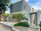 Modern two-story house exterior with driveway and greenery