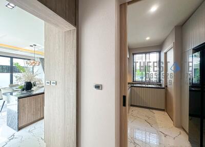 View of kitchen and dining area through a hallway