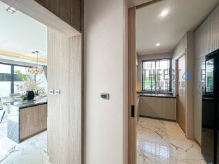 View of kitchen and dining area through a hallway