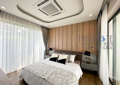 Modern bedroom with large windows and wooden flooring