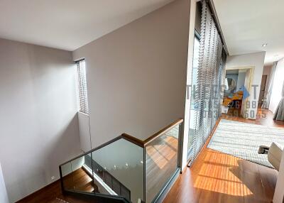 Modern staircase area with wooden flooring and glass railings