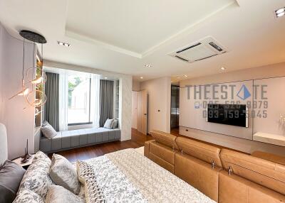 Modern bedroom with window seat and large TV