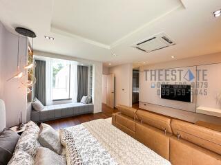 Modern bedroom with window seat and large TV