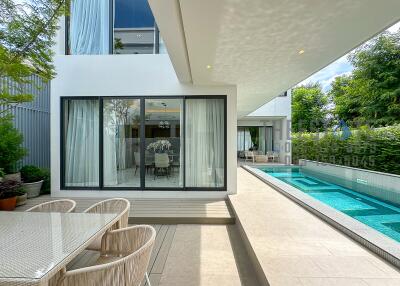 Modern outdoor living space with a swimming pool and dining area